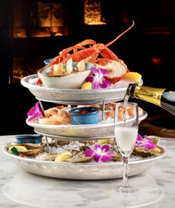 Champagne service pouring next to a seafood tower at Mercato della Pescheria, ideal for corporate dinners and group celebrations